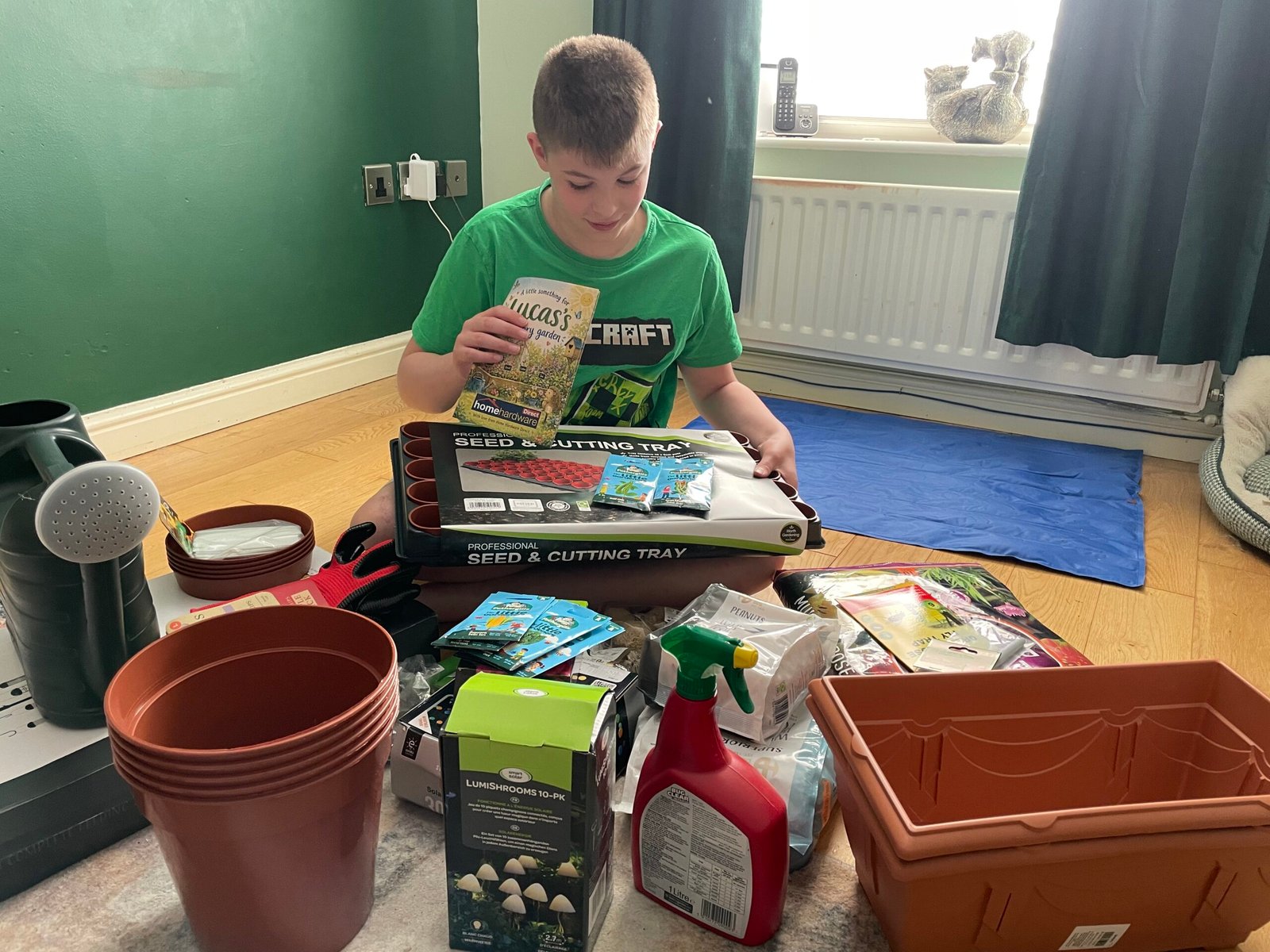 Lucas looking at seed packet from Home Hardware Pay It Forward donation Ayrshire